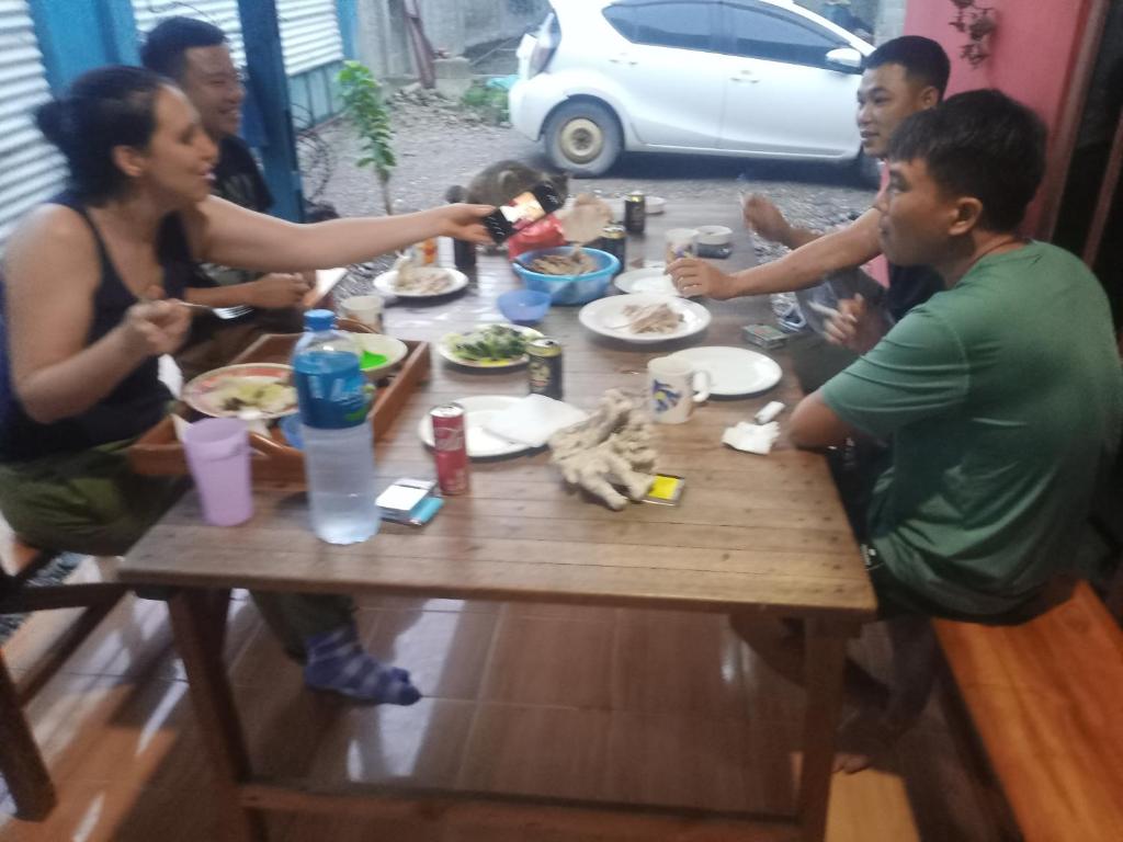 帝力Casa Minha Backpackers Hostel的一群坐在桌子旁吃食物的人