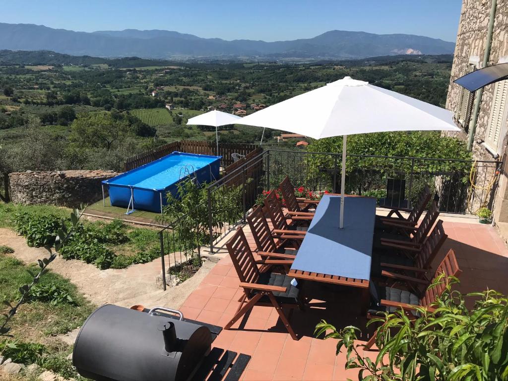 PiglioHouse near Rome with Beautiful Views and Pool的一个带椅子和遮阳伞的庭院和一个游泳池