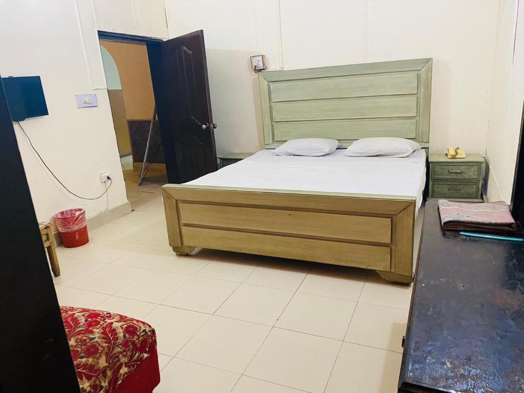 木尔坦Hotel New Star的一间卧室配有一张带木制床头板的床