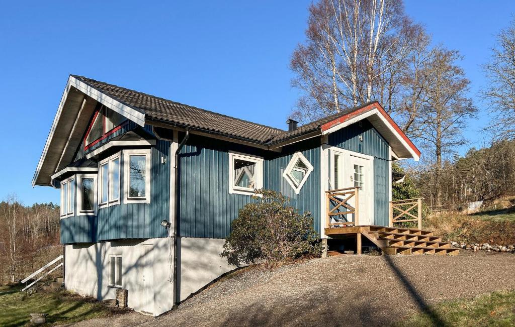 SundsandvikNice Home In Uddevalla With Kitchen的山丘上一座绿色和白色的小房子