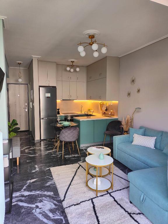 哈尔基斯Olivia Apartment-Private parking的一间带蓝色沙发的客厅和一间厨房