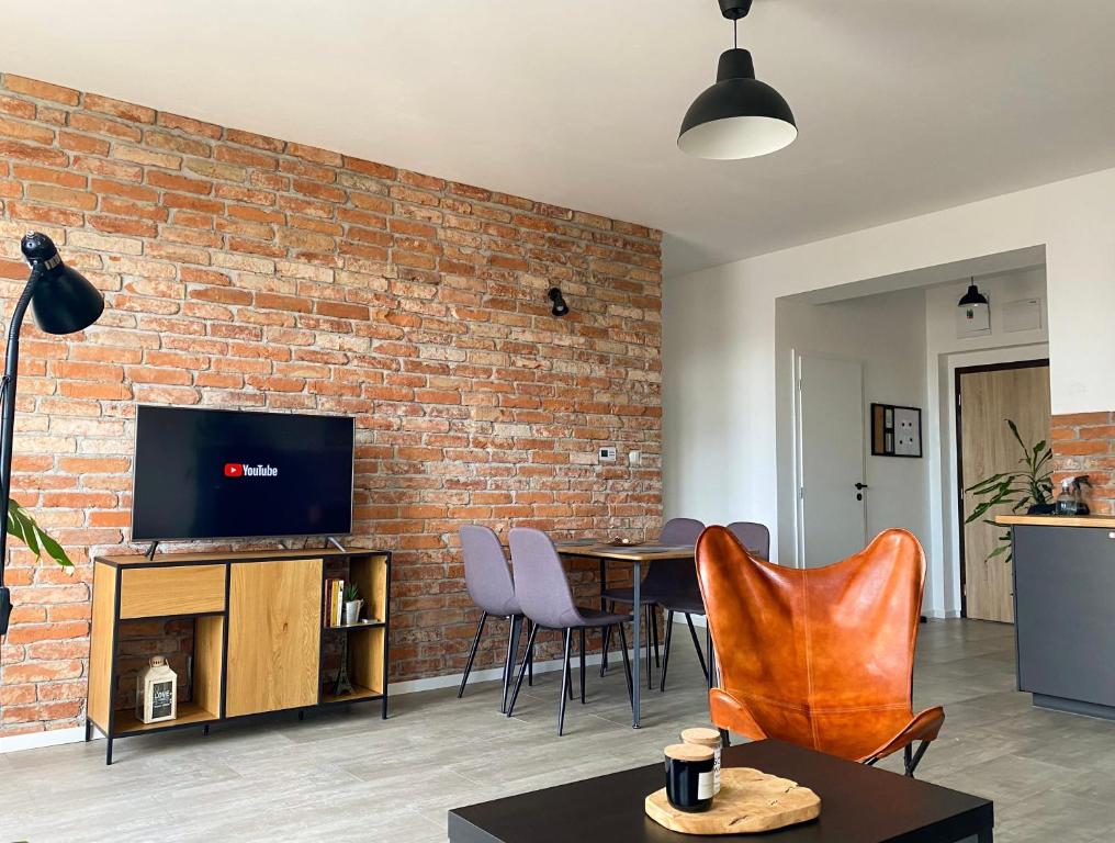 斯皮什新村Concordia apartment的一间设有砖墙和桌椅的客厅