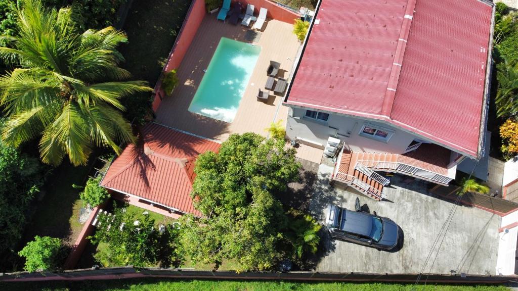 莱特鲁瓦西莱Résidence Belle Anse Trois-ilets的享有带红色屋顶和游泳池的房屋的顶部景致