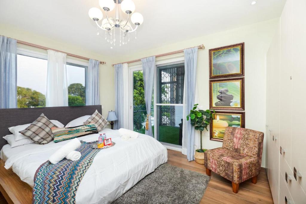 阿克拉Perfect Luxury @ Henrietta’s Residence的一间卧室配有一张床、一把椅子和窗户。