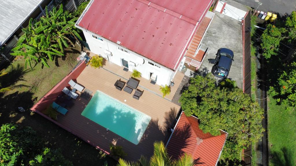 莱特鲁瓦西莱Résidence Belle Anse 6 Pers 3ilets的享有带游泳池和红色屋顶的房屋的顶部景致