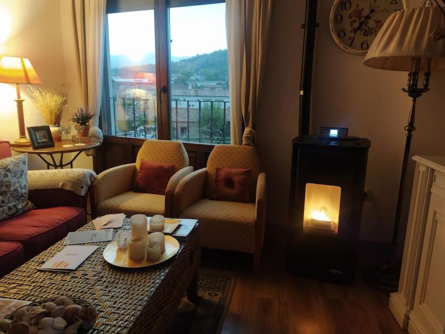 奥里韦拉德尔特雷梅达尔Apartamento Gandía, Orihuela del Tremedal.的客厅设有壁炉和带蜡烛的桌子。