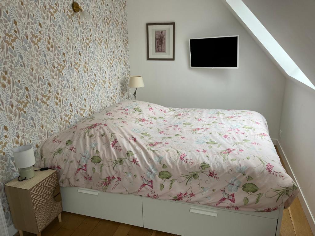 里尔Chambre privée Place aux oignons的白色卧室配有一张带花卉床罩的床