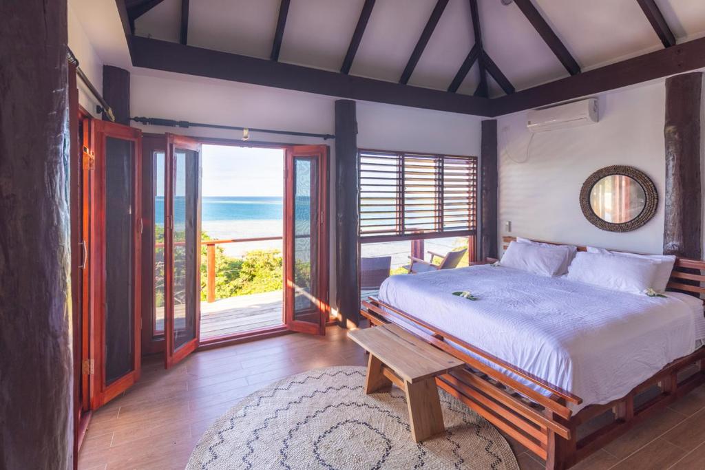 马洛洛Private Oceanfront Fijian Villa Sleeps 8的一间卧室设有一张床,享有海景