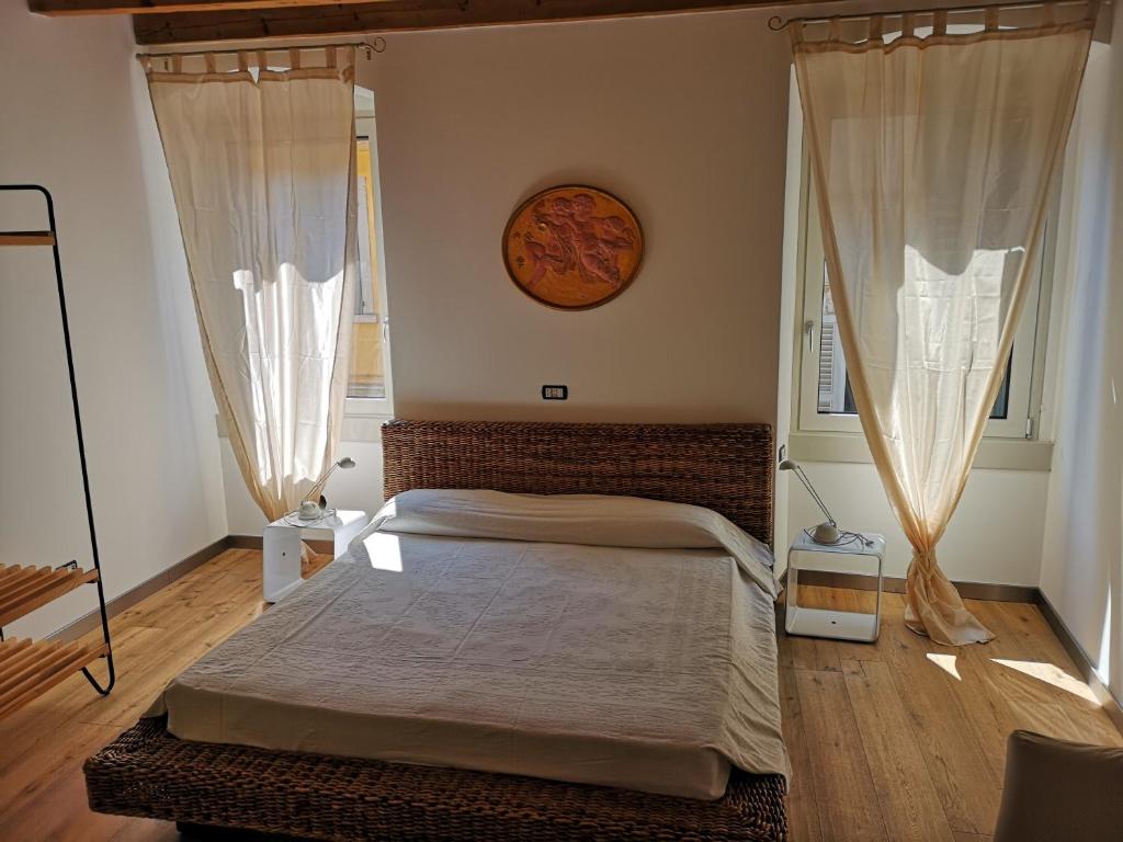 贝加莫Appartamento in centro Bergamo的一间卧室配有一张带窗帘的床和墙上的时钟