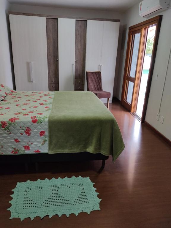 新彼得罗波利斯Nascer do Sol - Edelweiss的一间卧室配有一张带绿毯的床和一把椅子