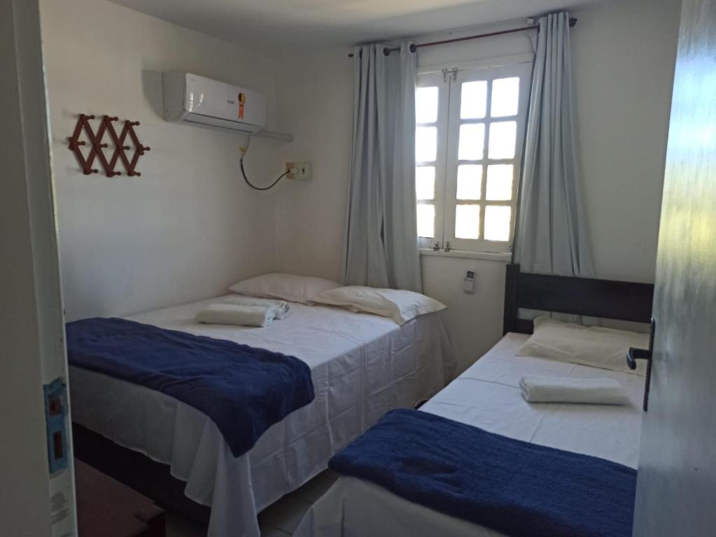 嘎林海斯港Privê Recanto da Enseada - Serrambi的带窗户的客房内的两张床