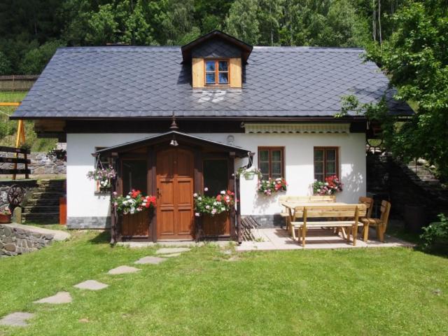 小莫拉夫卡Domeček Karlov的一个带桌子和木门的小房子