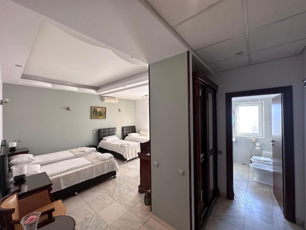 布加勒斯特Hotel Bliss的带三张床和浴室的客房