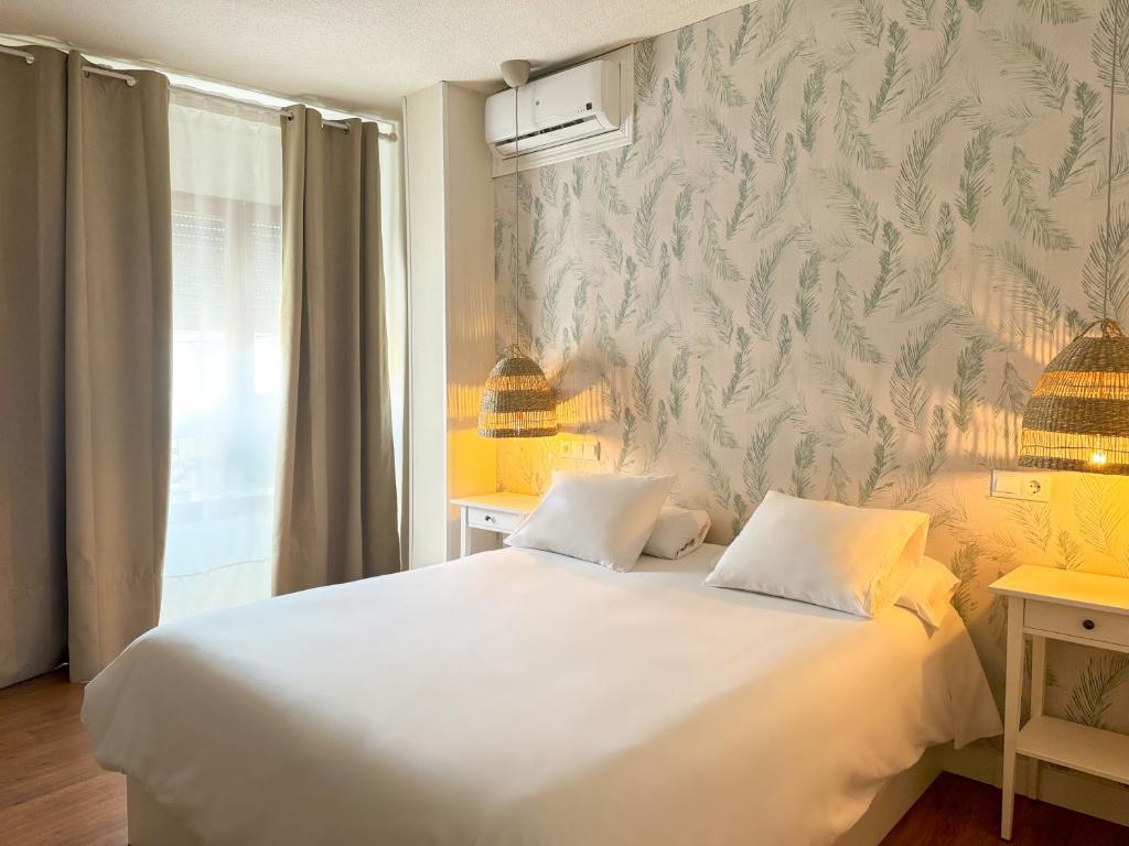 奥卡尼亚Hotel Plaza Mayor的卧室配有白色的床和墙壁