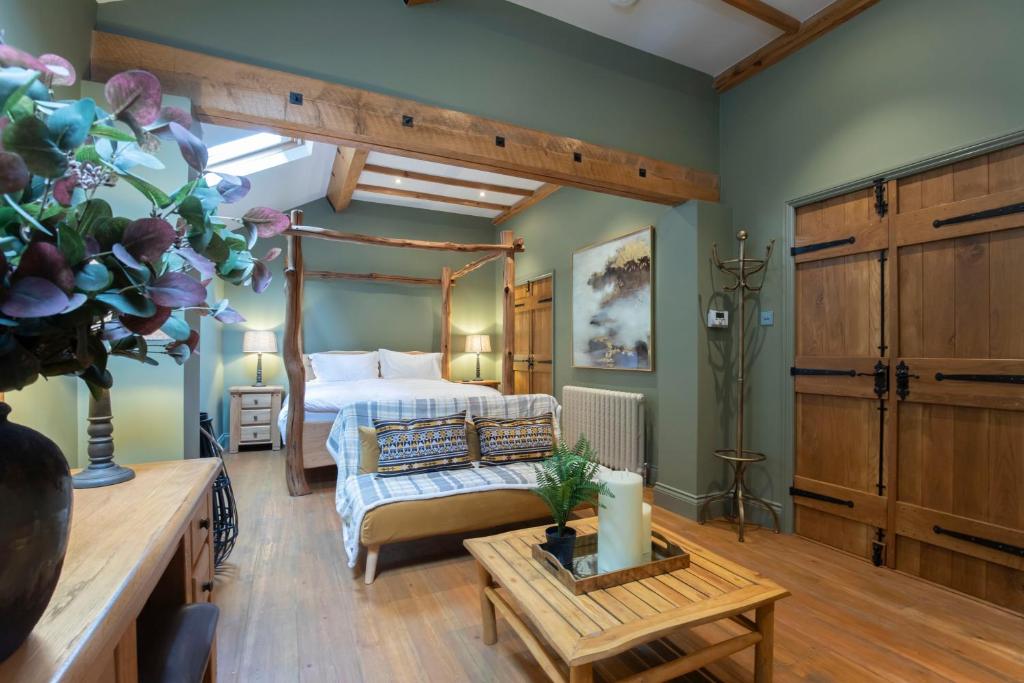 切尔滕纳姆Stable Lodge - Boutique Bed & Breakfast的一间大卧室,配有一张床铺和一张桌子