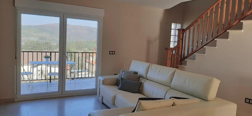 Cabana de BergantiñosCasa da Morriña的客厅设有白色沙发和楼梯。