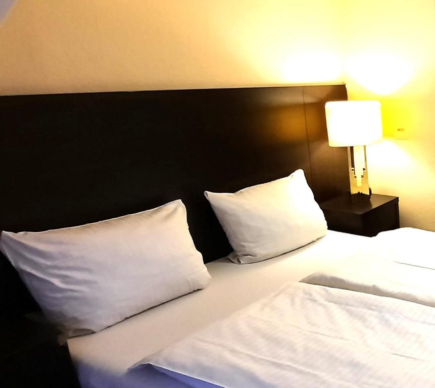 科隆阿里亚纳酒店的一张带白色枕头的床