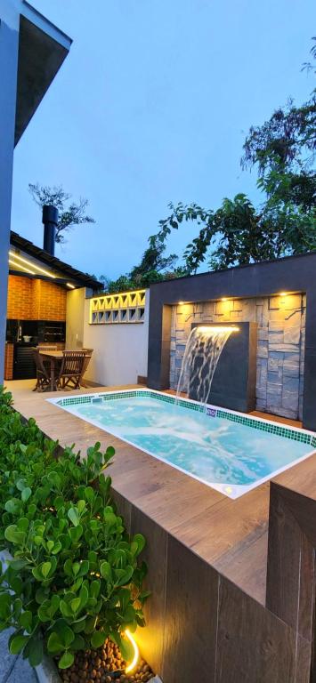 邦比尼亚斯Casa Sunstay Garden com piscina的后院的瀑布游泳池