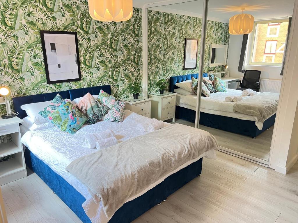 伦敦Luxe Haven King Bed En-suite & Double with Parking的一间卧室设有两张床和大镜子