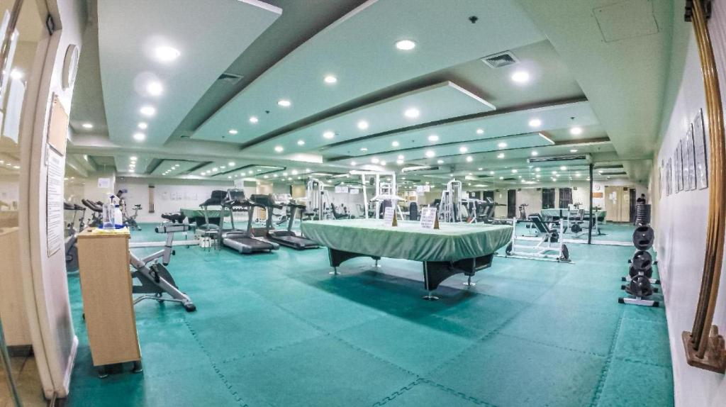 马尼拉Robinson manila birchtower的大型客房,设有健身房,地面绿色