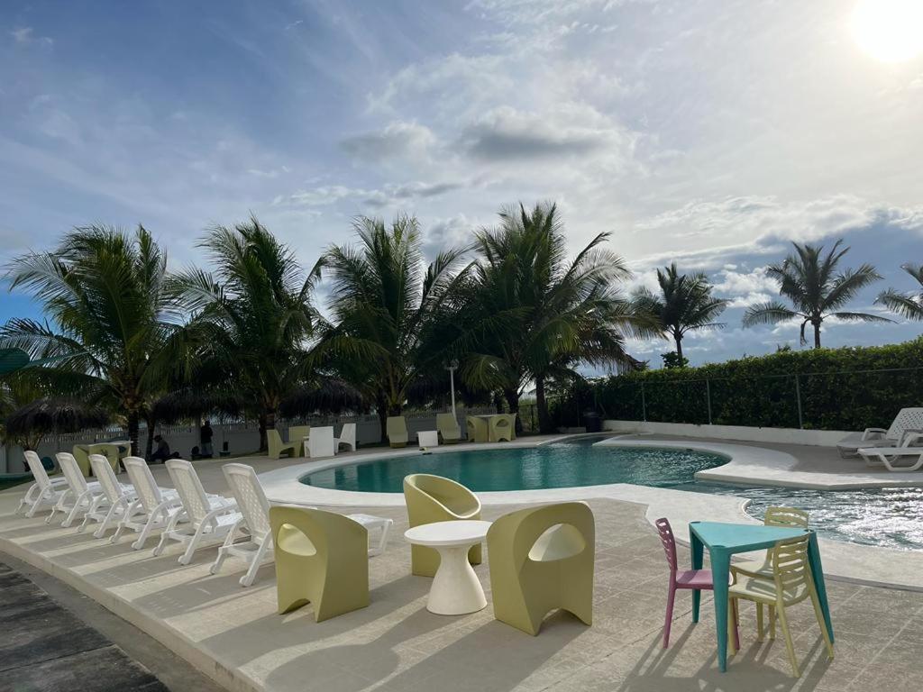 戴维Playa La Barqueta , Las Olas Tower Front的一组椅子和桌子,位于游泳池旁
