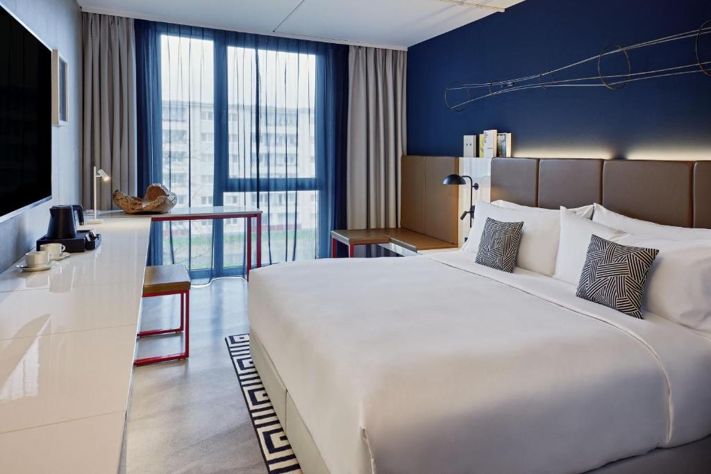 科隆the Deutz, a Tribute Portfolio Hotel的酒店客房设有一张大床和一张书桌。