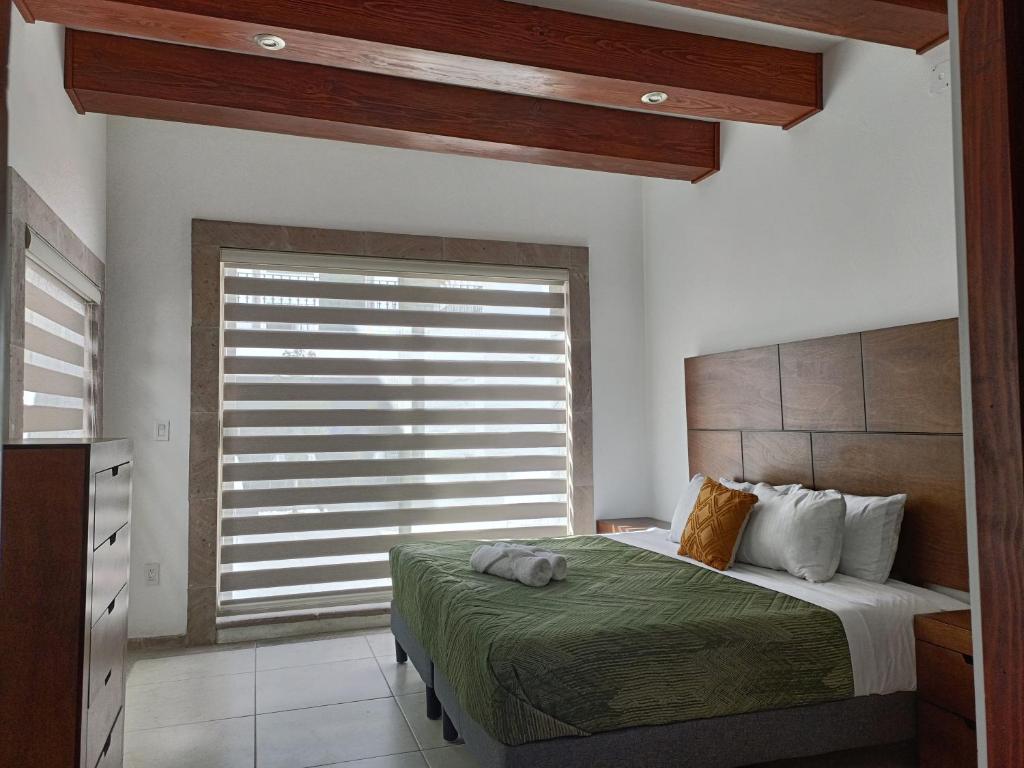莫雷利亚Los Arcos Hottel Boutique的一间卧室设有一张床和一个大窗户
