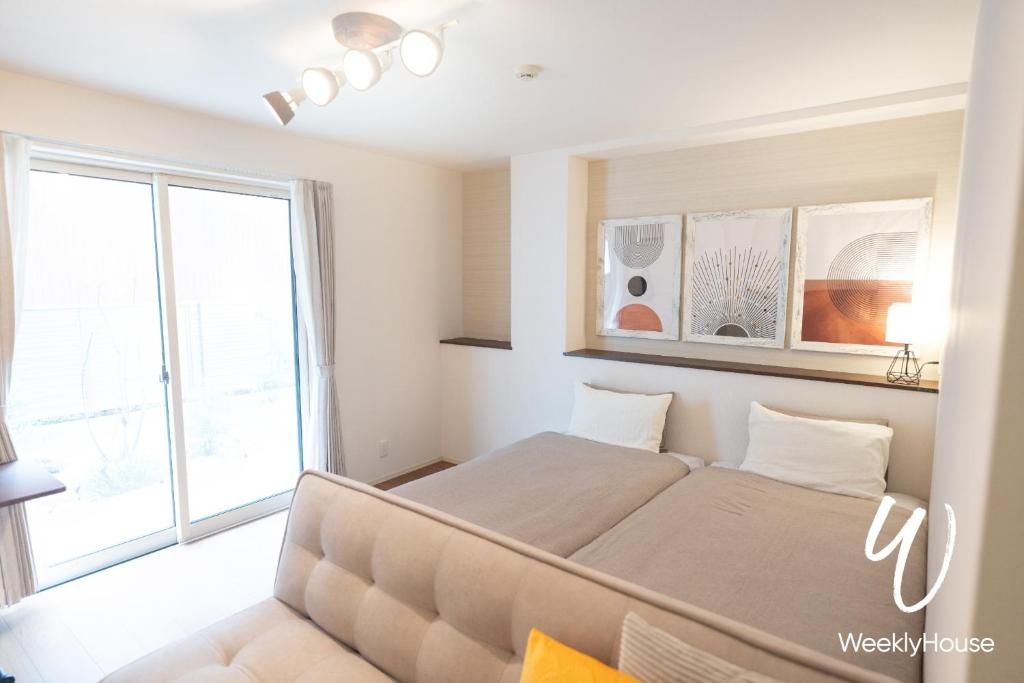 大津WeeklyHouse Silto Crete - Vacation STAY 14148v的一间卧室设有一张床和一个大窗户