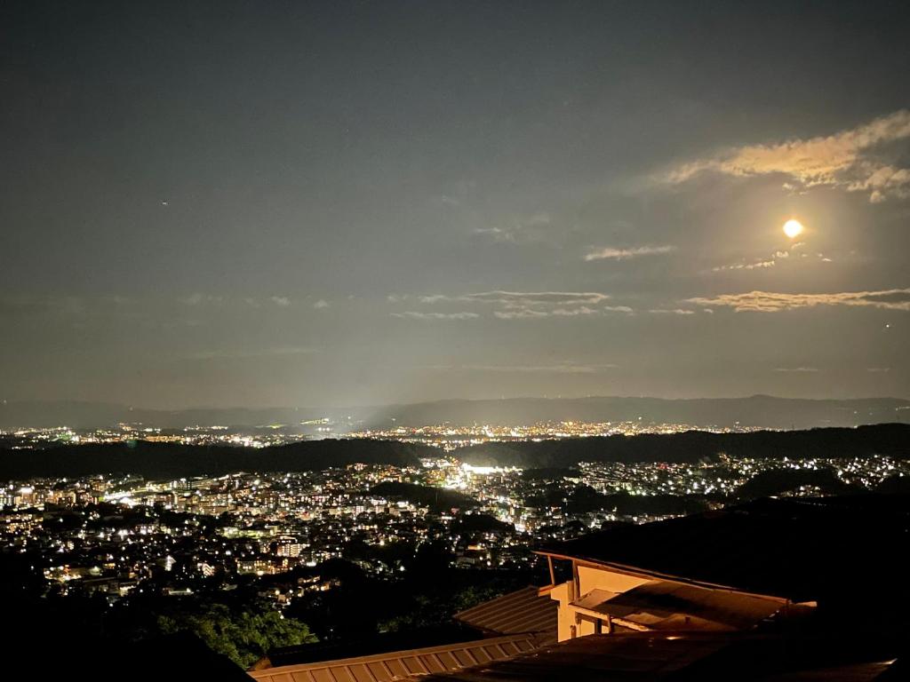 生驹Kanko Ryokan Yamato的夜晚城市与月亮的景观