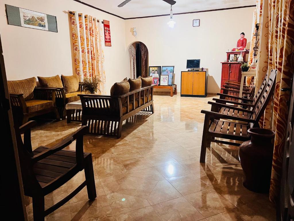 TudugalaCozy village house的客厅配有几把椅子和一张沙发