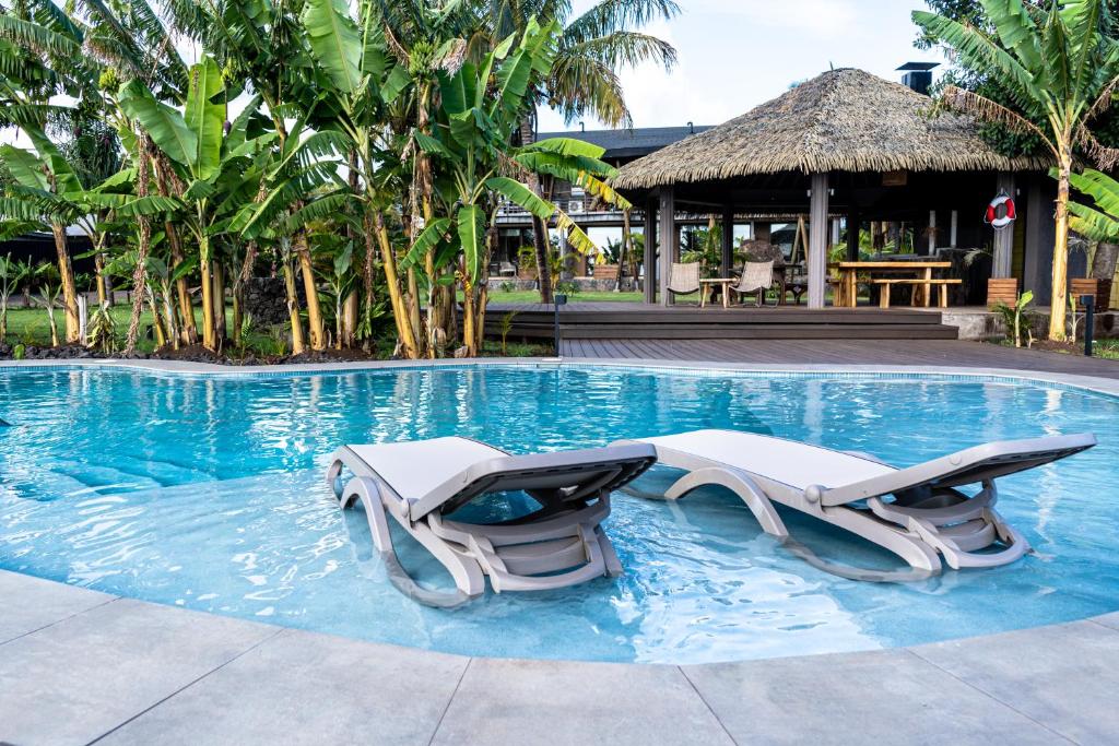 安加罗阿Hotel Ohana Rapa Nui的一个带两把躺椅的游泳池