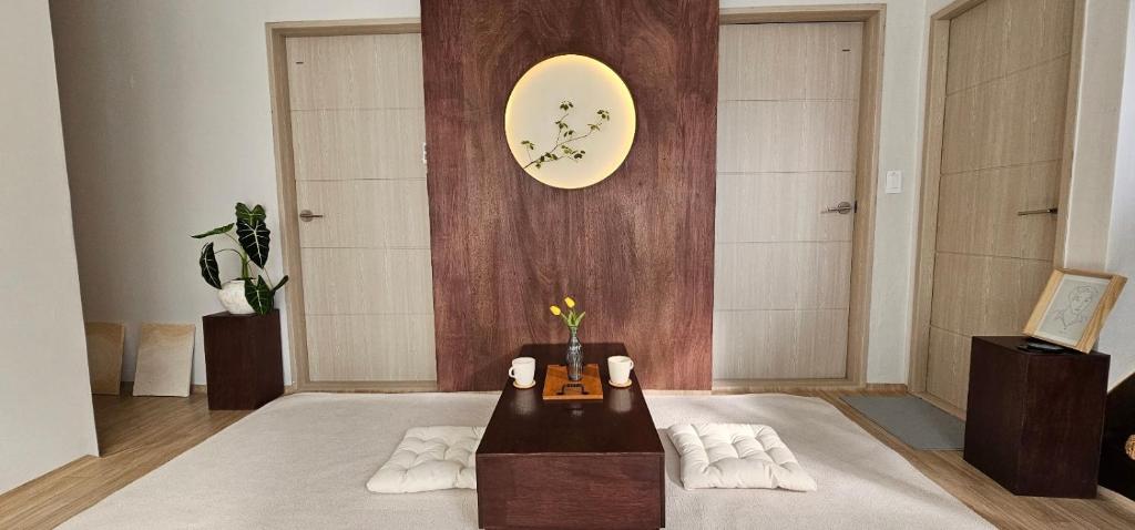 釜山Soban Stay的客厅配有桌子和墙上的时钟