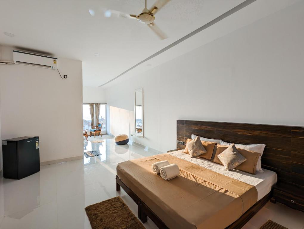 曼德姆Aqua Beach Resort Ashwem的一间卧室配有一张大床和木制床头板