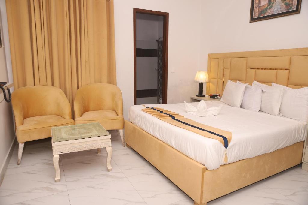 拉合尔Hotel Royal Comfort的一间卧室配有一张大床和一把椅子