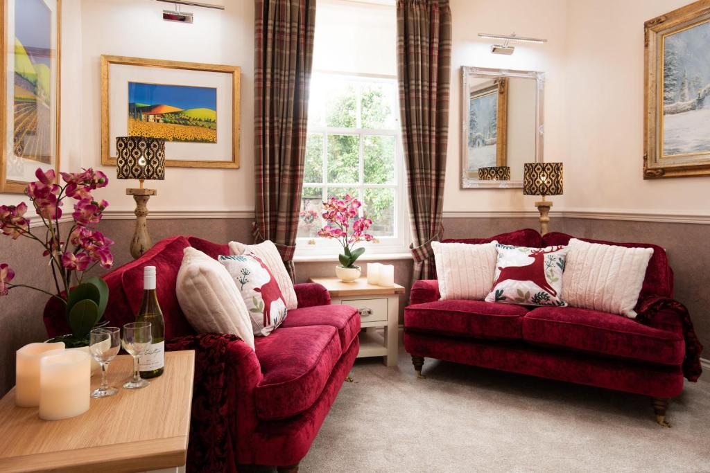 梅尔罗斯Bank View的客厅配有两张红色的沙发和一张桌子