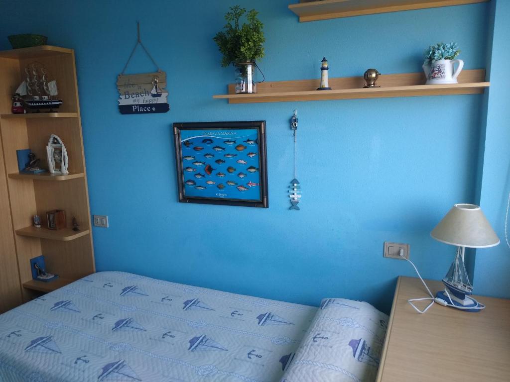 福斯Apartamento en Foz Entreplayas的一间卧室设有蓝色的墙壁和床