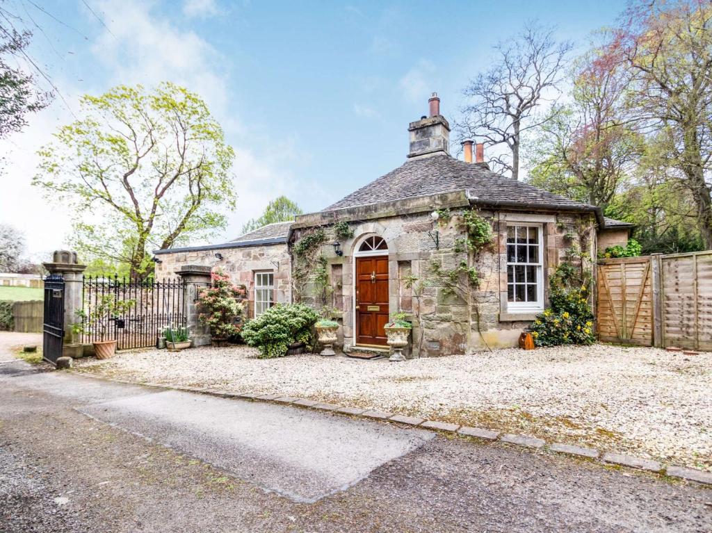 Lasswade3 Bed in Edinburgh 87264的一座带红色门的古老石屋