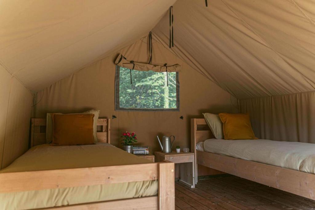 米瑞德Ca Stella Camping del Monte San Giorgio的一间帐篷内带两张床的卧室