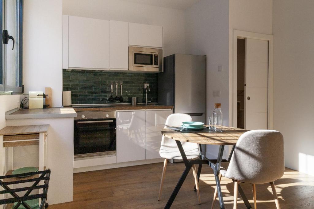 马德里Simancas by SharingCo的厨房配有白色橱柜和桌椅