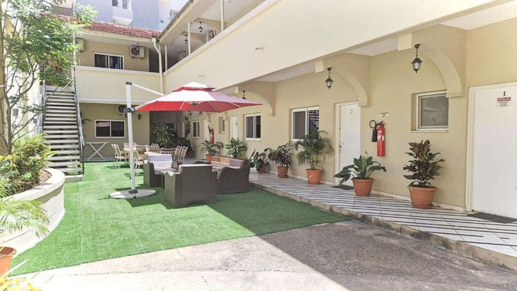 罗安达CASA NATALIA - Guesthouse的户外庭院配有椅子和遮阳伞。