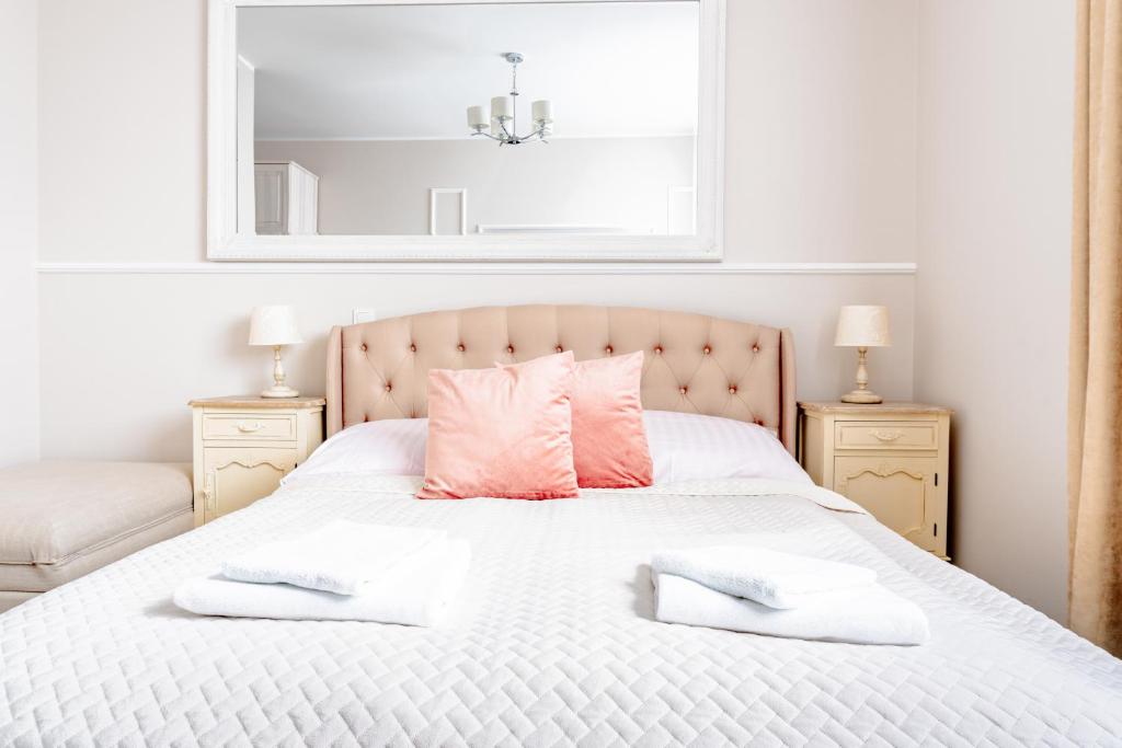 OsłoninoFilip Pokoje - Osłonino nad zatoką的卧室配有白色床和粉红色枕头
