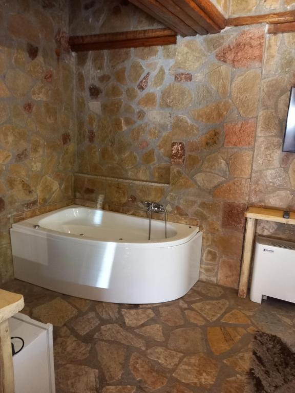 卡拉维塔Ζachlorou Mood的带浴缸的浴室和石墙