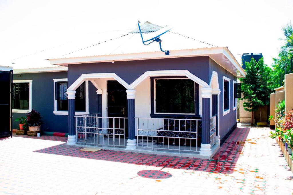 莫希Stay in Bomang'ombe with Breakfast的一个小的蓝色和白色房子,有车道
