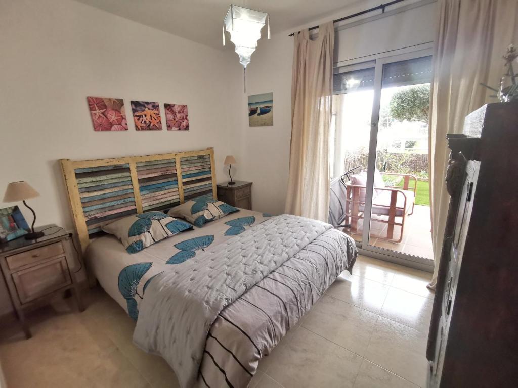 兰卡Apartament a les cales de Llançà en residència privada amb piscina的一间卧室设有一张床和一个滑动玻璃门