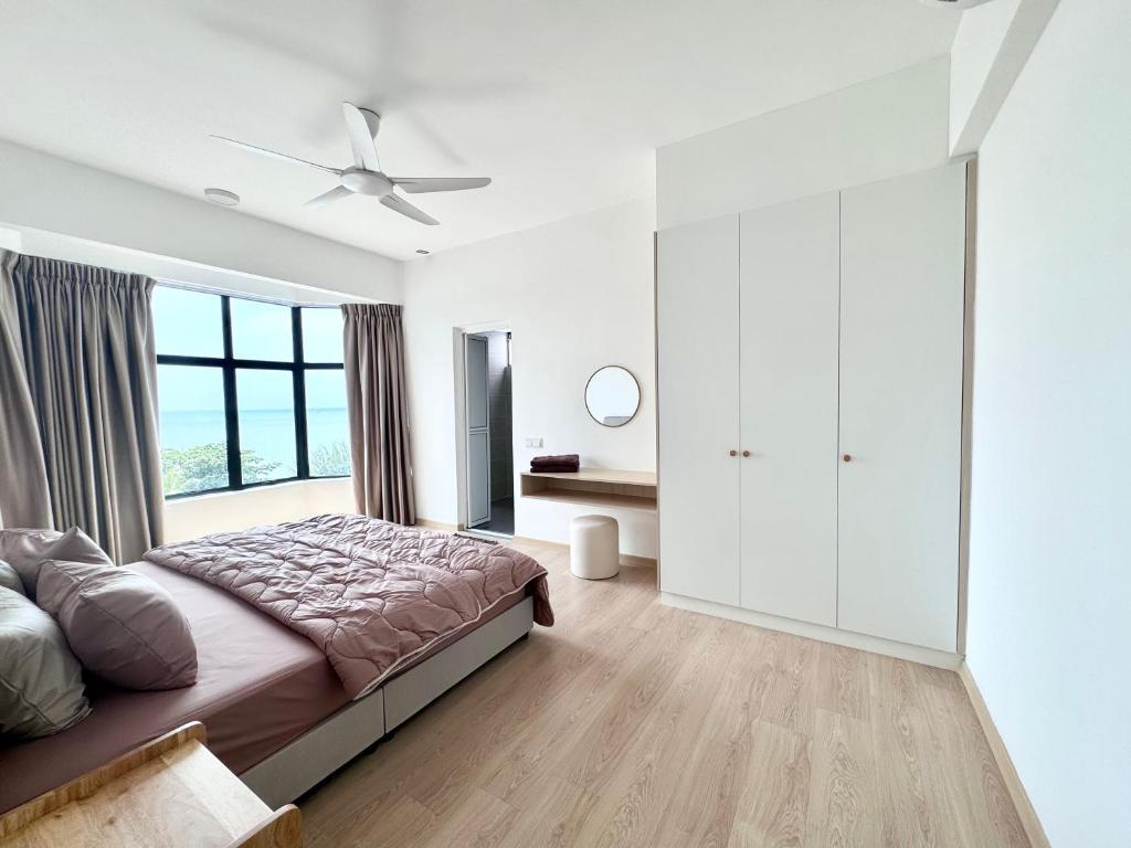 Tangga BatuSeaview 2 bedroom apartment Mutiara Beach Resort by ISRA的一间卧室设有一张床和一个大窗户