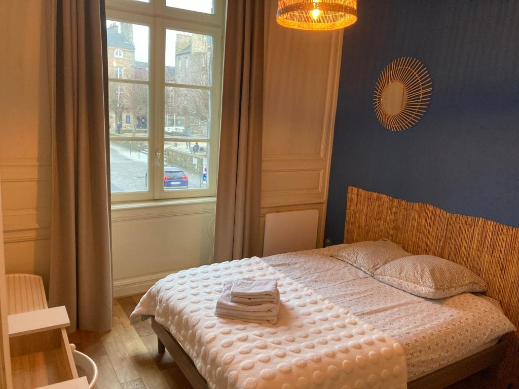 迪南L'Aparthé Dinan - Vue sur la place du marché的一间卧室配有带毛巾的床