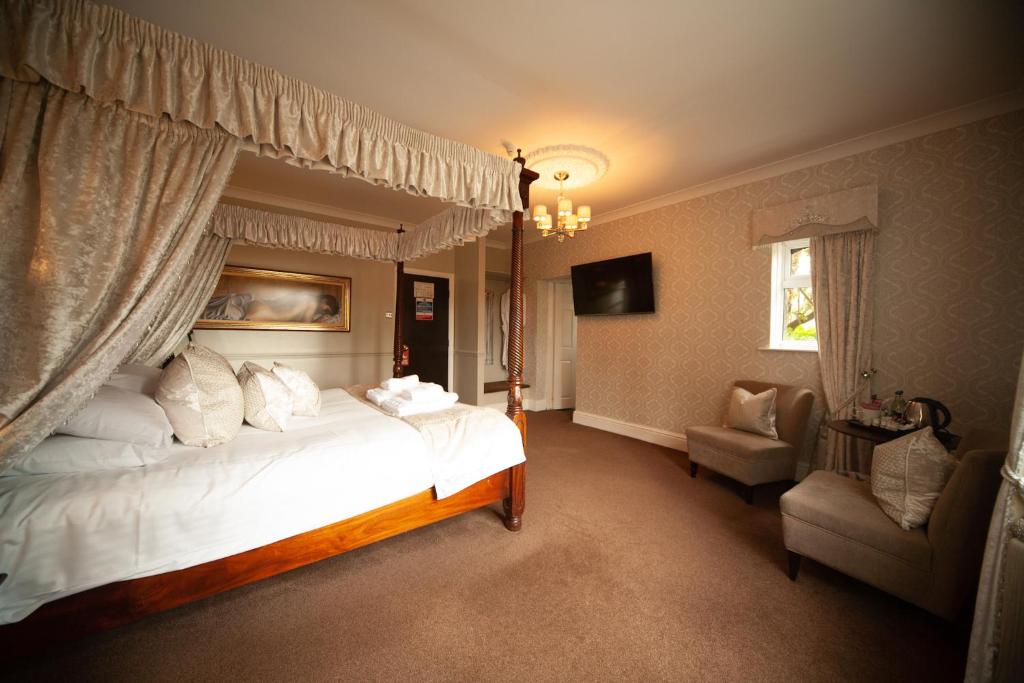 劳斯布莱克区酒店的一间卧室配有一张大床和一把椅子
