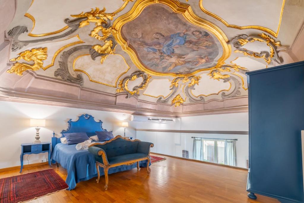 巴勒莫Natoli Apartments的卧室配有蓝色的床和墙上的绘画作品