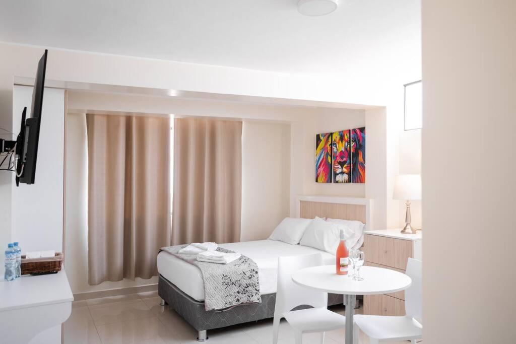 利马Residencial Suiza的白色卧室配有床和桌子