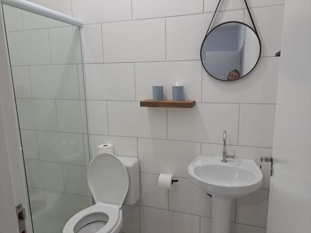 博西坎加Casa nova com 3 quartos, equipada com Ar Condicionado, TV, Internet e Área de Lazer Completa - Boiçucanga的一间带卫生间、水槽和镜子的浴室